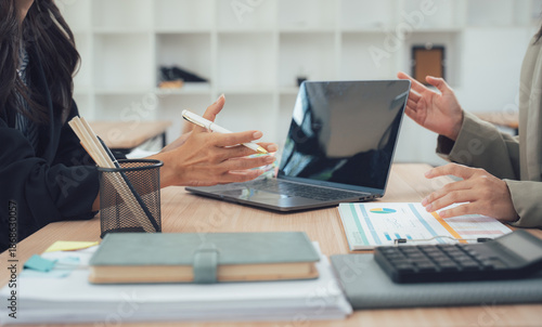 Business discussion: A detailed shot of two individuals engaged in a dynamic business discussion within a modern office setting. Captured at eye-level to depict clarity and collaboration.