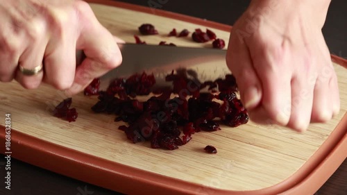 Chopping Dried Cranberries on Wooden Cutting Board