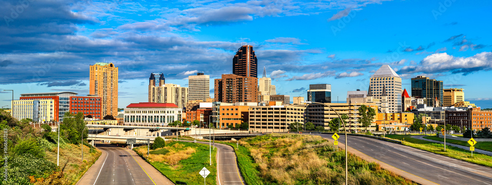 Fototapeta premium Saint Paul skyline stands in Minnesota, USA. Cityscape view features downtown skyscrapers and highway roads under a blue sky with clouds in the Twin Cities