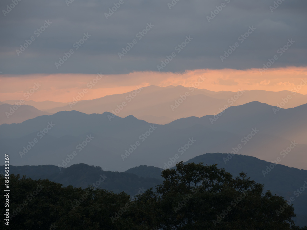 Obraz premium Cloudy sunset palette of shades of brown, orange and gold viewed from the Craggy Gardens Outlook outside Asheville North Carolina towards the Great Smokey Mountains of Tennessee