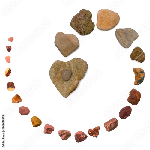 Heart-shaped stones arranged in a circular pattern on white background