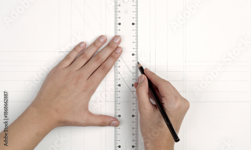Photos a woman's hands drawing with rulers on paper