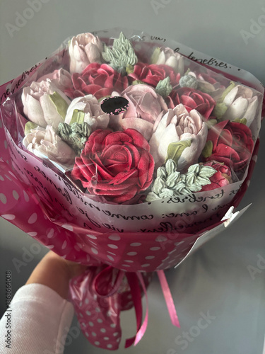 Marshmallow bouquet in a woman's hand. Marshmallow flowers of different colors close-up. The work of a marshmallow manufacturer entrepreneur.