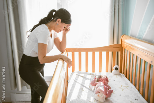 Side view of unhappy frustrated young mother in child bedroom
