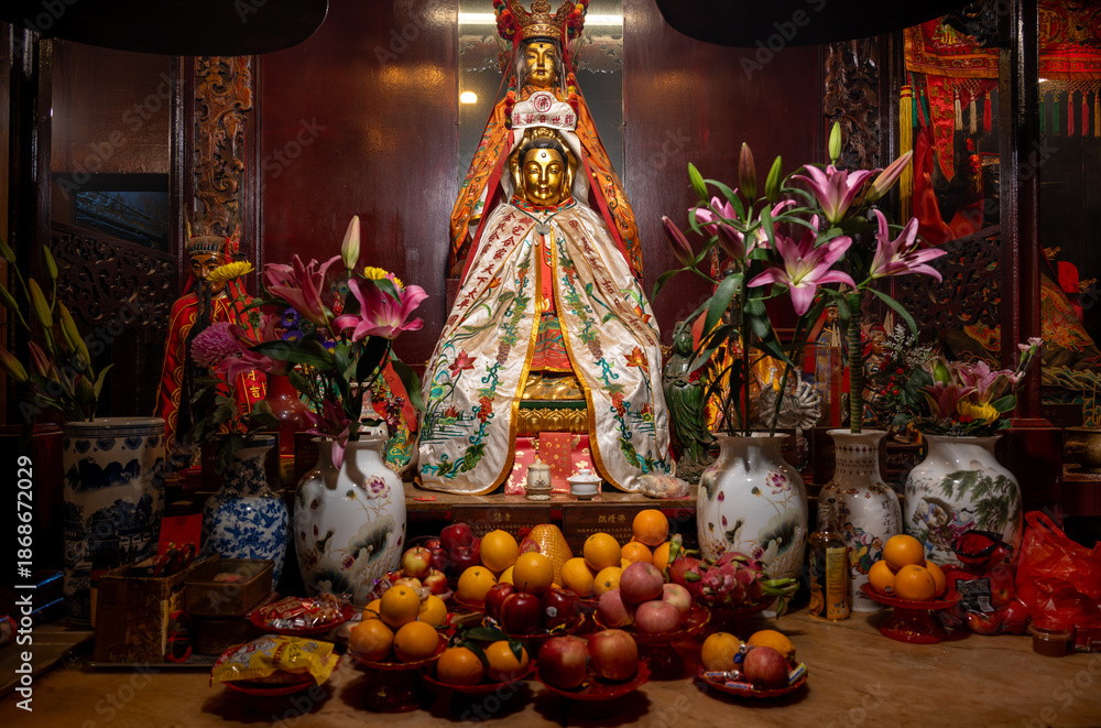 Fototapeta premium Man Mo Temple, Hong Kong, China : altar with Taoist deity statue, offerings of fruit and flowers inside the historic temple near Hollywood Road
