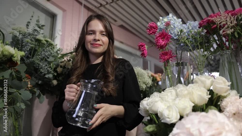 Florist woman holding water pitcher in a flower shop