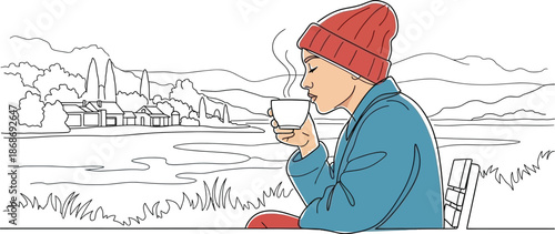 Woman wearing a bright red beanie and blue jacket enjoys a steaming hot beverage outdoors in a serene rural landscape setting