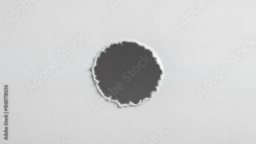 A dark hole with a rugged edge on a surface. The hole is isolated and has a shadowy appearance