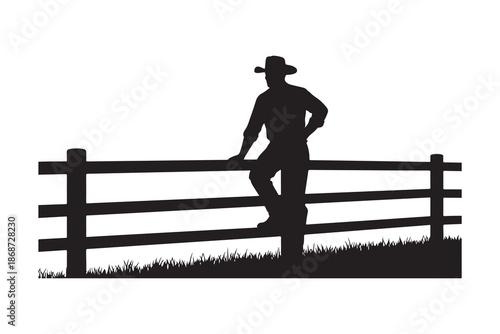 Silhouette of a cowboy leaning on a wooden fence in a field
