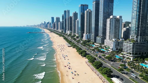 Coastal cityscape with buildings and beach under clear blue sky