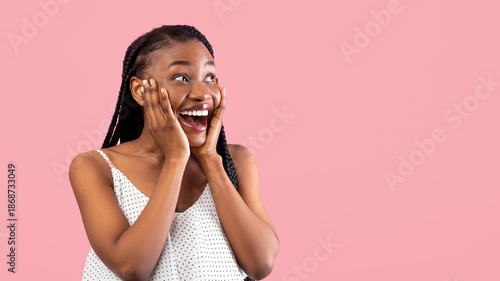Wallpaper Mural Emotional black woman in summer dress touching her face, looking aside at empty space in excitement on pink studio background, panorama. Glamorous young lady advertising something Torontodigital.ca