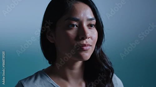 Confident young woman with long dark hair in casual gray t-shirt