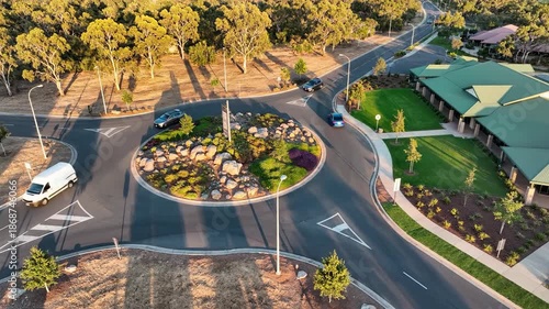Aerial view of a roundabout with traffic trees and buildings
