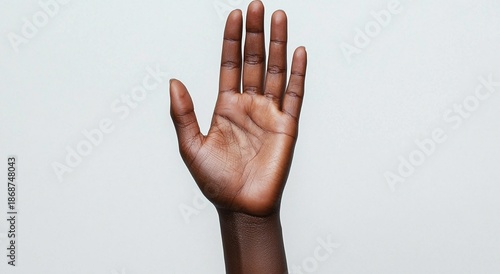 Darkskinned hand with palm facing forward and fingers spread