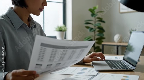 Businessman analyzing financial documents at modern office desk