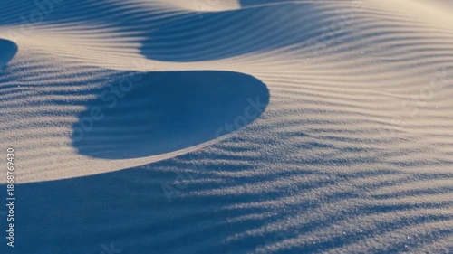 Sand Dunes Ripple Texture Underneath a Clear Sky at Sunrise with Warm Sunlight