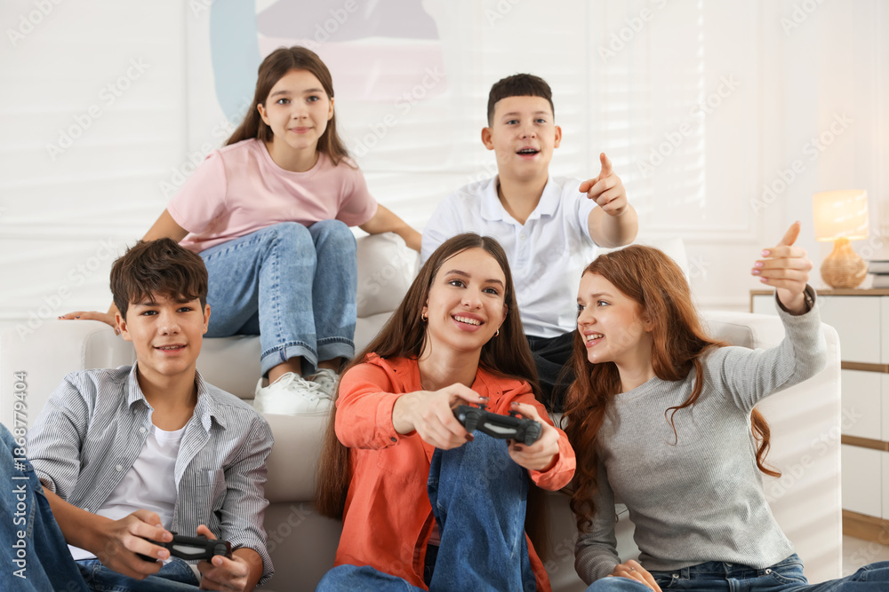 Obraz premium Happy teenagers playing video game together at home