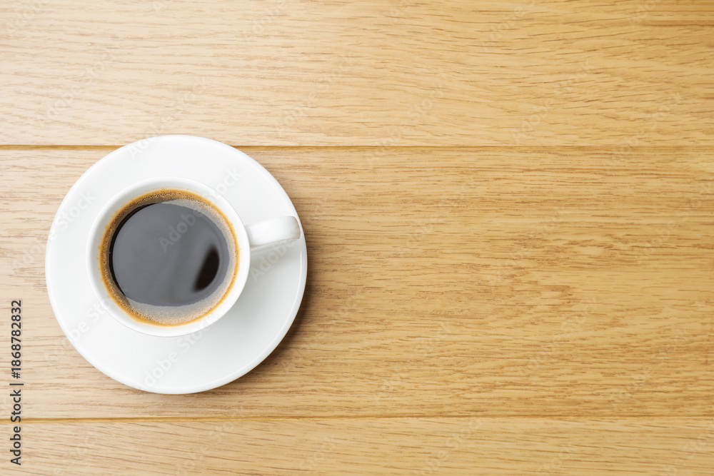 Obraz premium Aromatic coffee in cup on wooden table, top view. Space for text