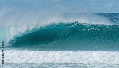 Large Wave Breaks at the Beach in Daytime With Blue Sky and White Clouds Above
