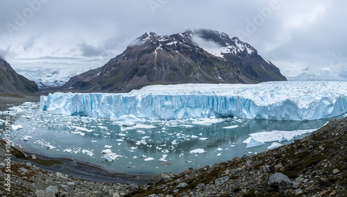 Glacier Flows Into Water Body Beneath Cloudy Sky in Remote Location