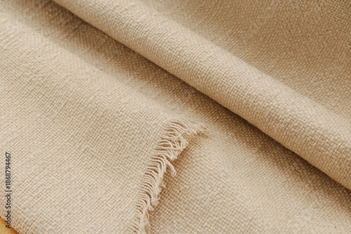 Macro close-up of natural linen fabric texture showing woven fibers and detailed surface in soft beige tones. Perfect for textiles, fashion, interior design, and abstract backgrounds.