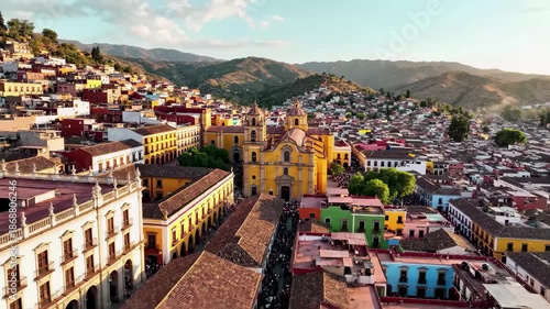Aerial view of colorful colonial city architecture and hills under a bright sky