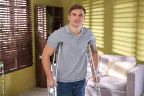 Slika na platnu Injured man using axillary crutches at home