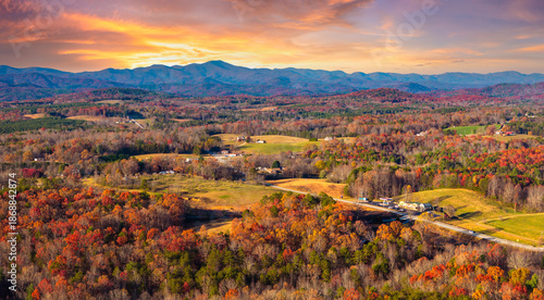 Obraz na plátně Scattered houses and homesteads in vibrant forest in fall season on Appalachian mountain range