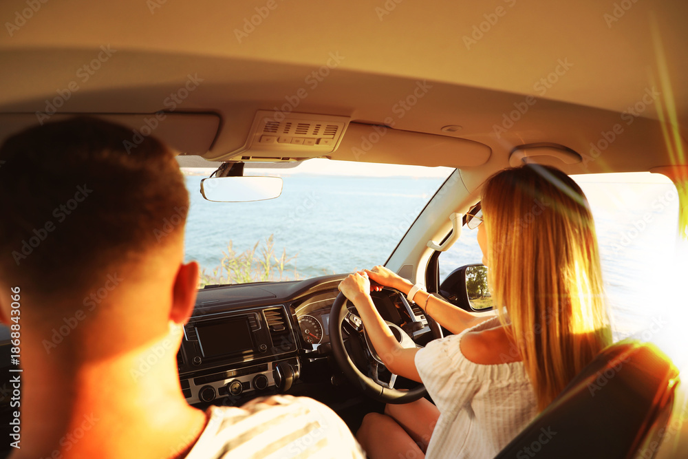 Naklejka premium Couple in car near sea on sunny day