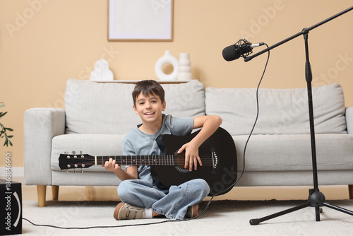 Smiling boy playing acousti...