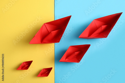 Red paper boats on colorful...