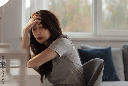 Sad young Asian woman sitti...