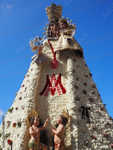 Las Fallas Festival 2025 in Valencia, Spain. A traditional celebration of spring and fire. The Virgin Mary's figure in Plaza de la Virgen, decorated with flowers, after the La Ofrenda procession.