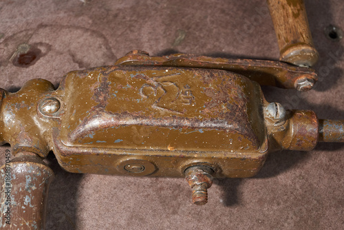Vintage metal hand drill with wooden elements and visible wear. Traditional manual drilling tool representing craftsmanship, repair work, and historical technology.