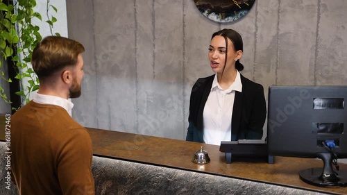Hotel receptionist greeting guest and providing room key card
