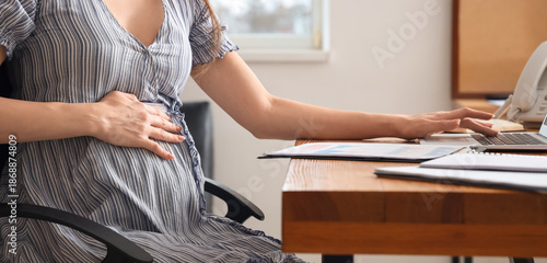 Pregnant businesswoman work...