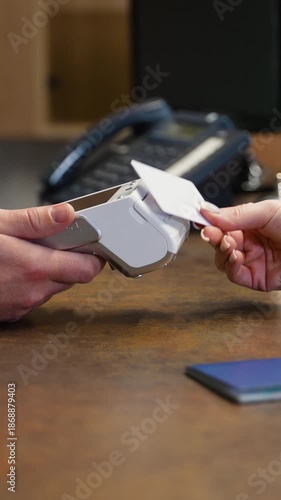 Guest paying with contactless card at hotel reception desk