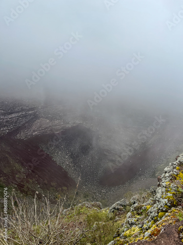 Foggy close-up view of the volcanic crater at the summit of Mount Bisoke in Rwanda.