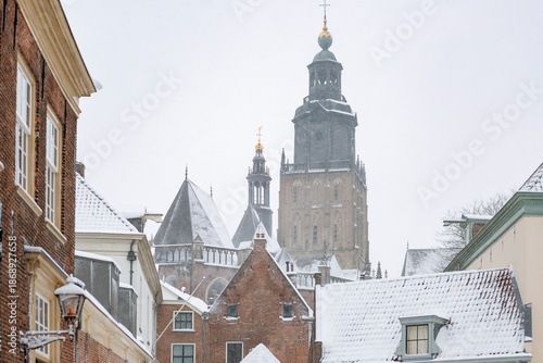 Rooftops full of snow in historic tower town Zutphen, Netherlands, with Walburgiskerk towering above medieval houses