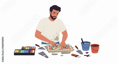 Bearded man working on a colorful mosaic art project, applying tiles with grout and surrounded by construction tools.
