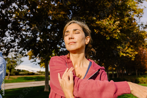 Middle-aged woman performing arm stretching exercises