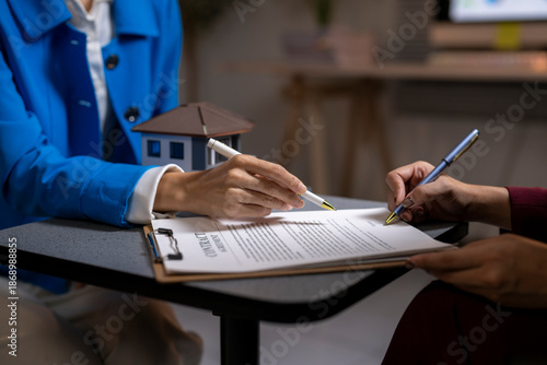 Real estate agent assisting client signing house contract