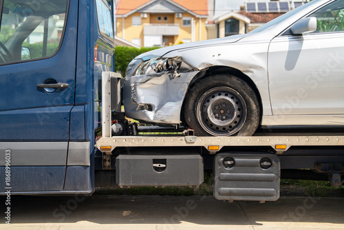 Slika na platnu A closer view of the front-left side of a silver car with collision damage and a