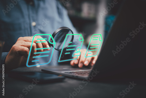 Person using magnifying glass to examine digital documents on laptop