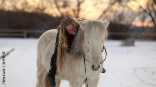 Happy rider stroking her horse on a winter arena showing joy affection trust and a deep emotional equestrian bond