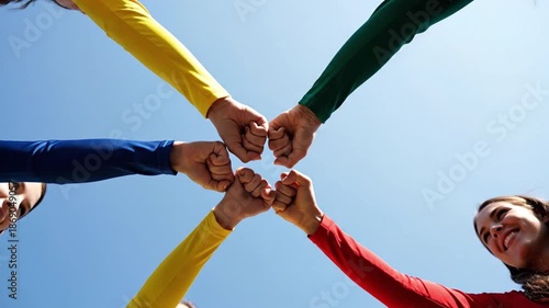 Hands in Harmony: A vibrant display of unity and solidarity, as a diverse group of individuals comes together in a symbol of teamwork, camaraderie, and shared purpose against a backdrop of a clear.
