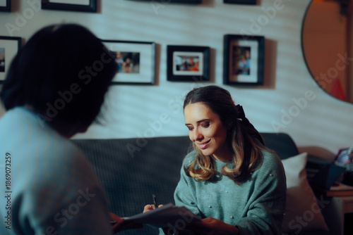 Canvas Print Woman Signing some Documents at Home on the Couch