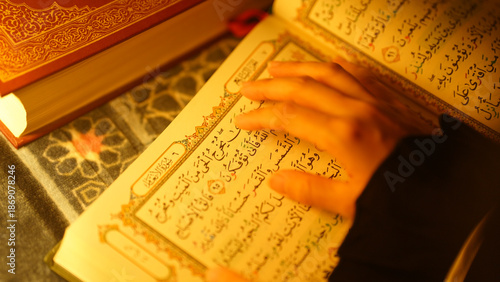 A close-up of a hand touching verses in the Quran during reading, symbolizing faith, focus, and spiritual connection in Islamic practice.