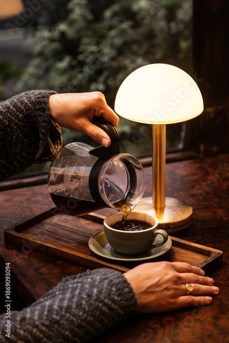 Canvas-taulu A woman serving freshly brewed coffee into a coloured cup in a coffee shop