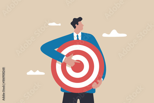 Businessman holding a target board and pointing towards the center
